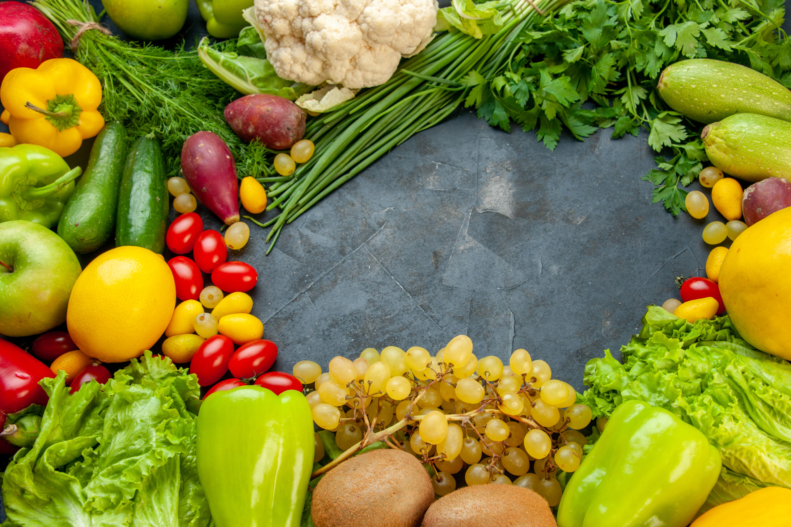 bottom-view-vegetables-fruits-cumcuat-lettuce-zucchini-bell-peppers-kiwi-grapes-parsley-green-onion-cauliflower-cherry-tomatoes-lemon-free-space